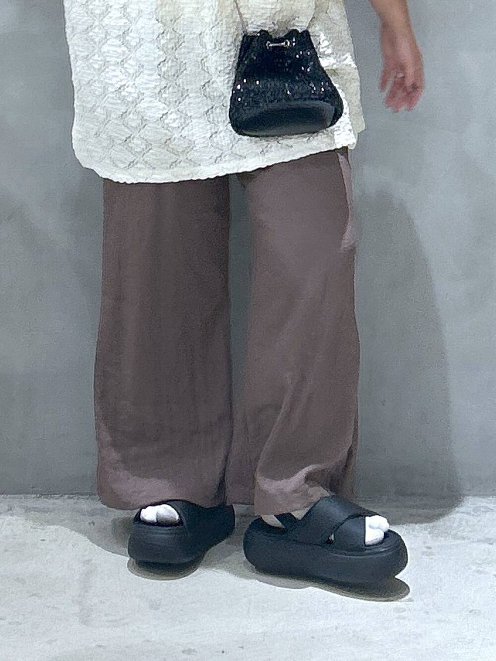 ブラック系のショルダーバッグ、ホワイト系のタンクトップ、ブラック系のサンダルを着用したレディースの夏コーディネートの4枚目の写真