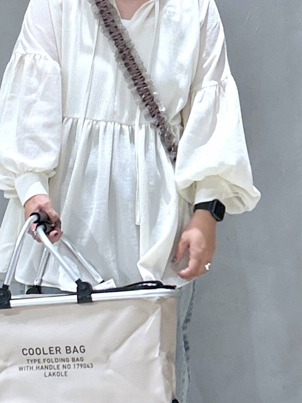 ブルー系のデニムパンツ、ホワイト系のチュニック、その他のサングラスを着用したレディースの秋コーディネートの3枚目の写真