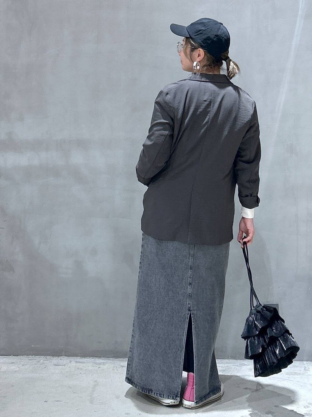 ブラック系のショルダーバッグ、ブラック系のジャンパースカート、グレー系のテーラードジャケットを着用したレディースの冬コーディネートの2枚目の写真