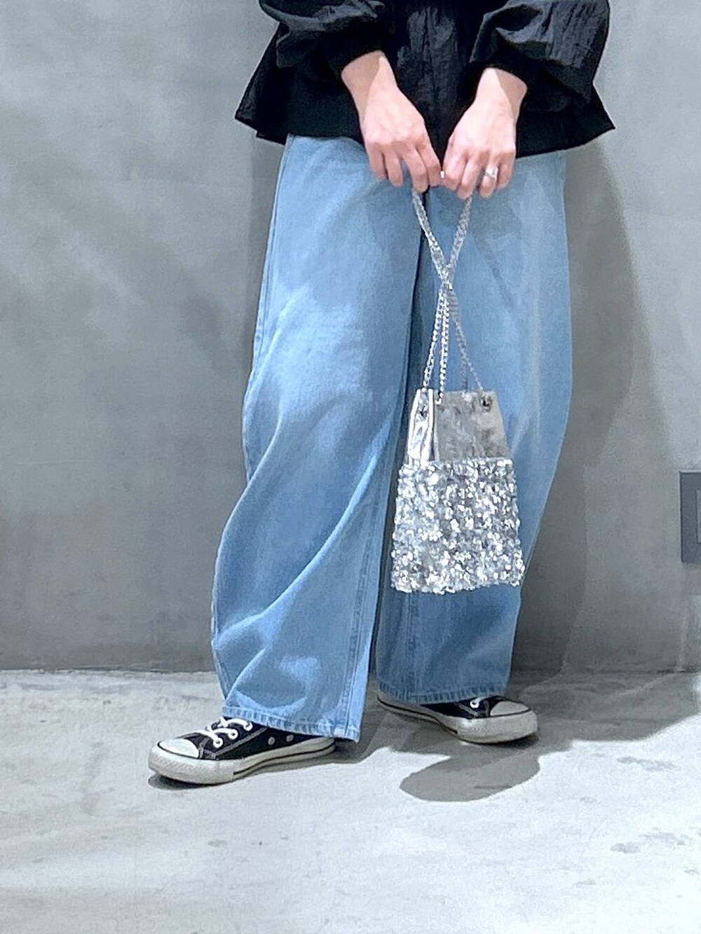 ブルー系のデニムパンツ、ブラック系のスウェット、その他のショルダーバッグを着用したレディースの冬コーディネートの4枚目の写真