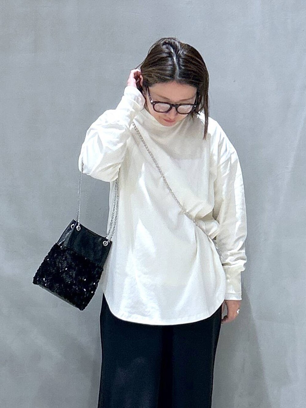 ブラック系のその他パンツ、ブラック系のショルダーバッグ、ベージュ系のTシャツ/カットソーを着用したレディースの冬コーディネートの3枚目の写真