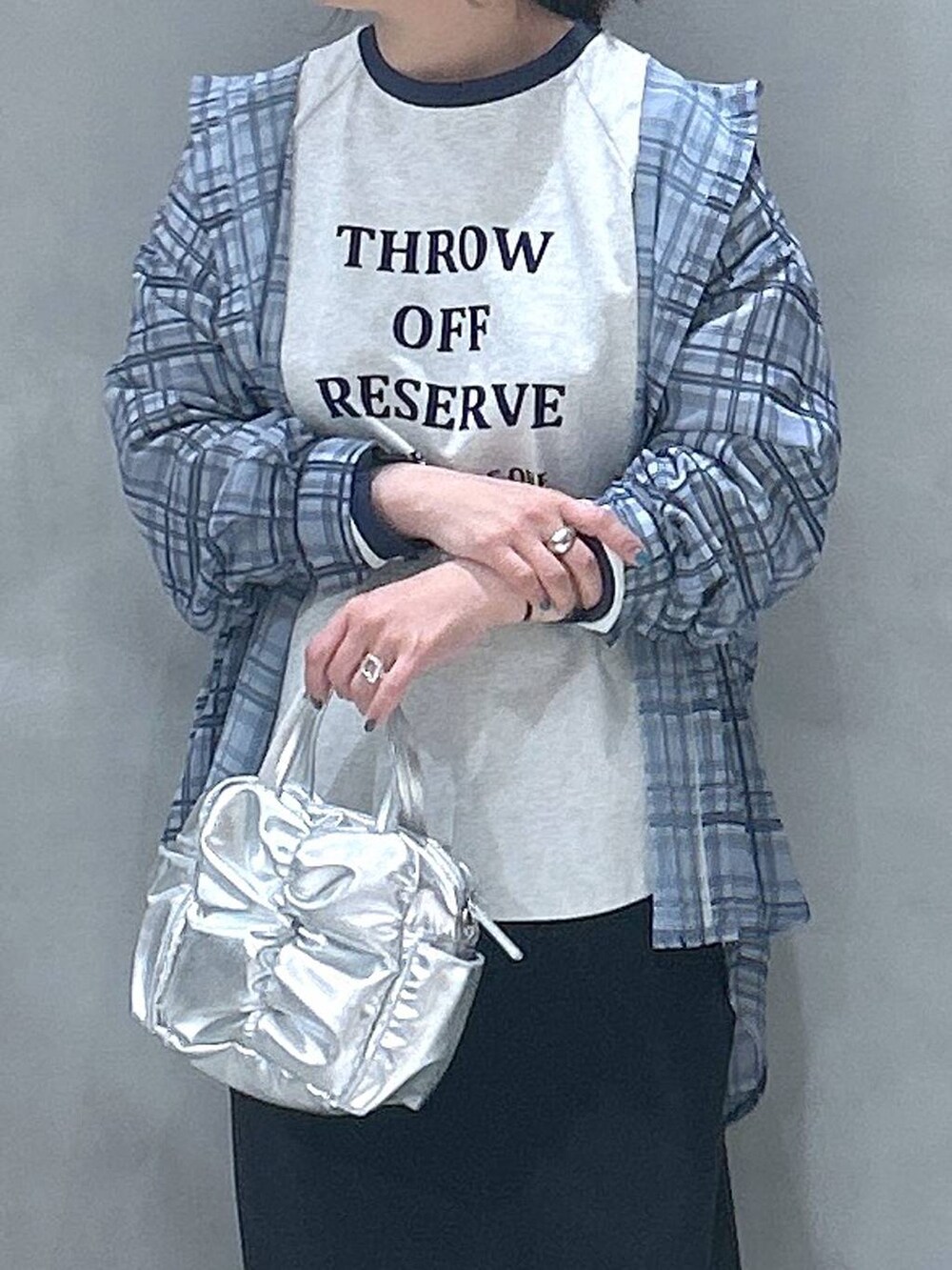 ブラック系のスカート、ベージュ系のTシャツ/カットソー、ブルー系のシャツ/ブラウスを着用したレディースの春コーディネートの3枚目の写真