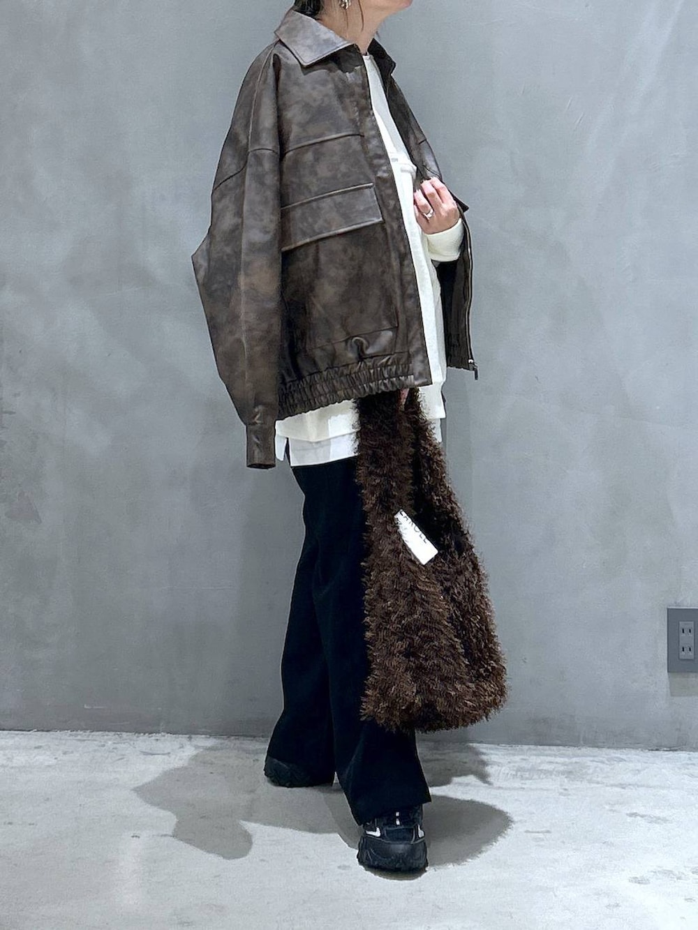 グレー系のスニーカー、ブラウン系のブルゾン、ブラウン系のショルダーバッグを着用したレディースの冬コーディネートの5枚目の写真