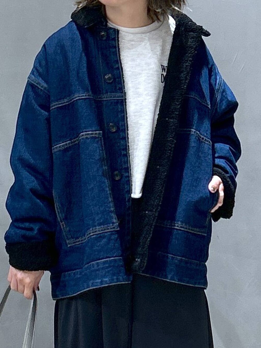 ブラック系のスカート、その他のショルダーバッグ、ブルー系のブルゾンを着用したレディースの冬コーディネートの3枚目の写真