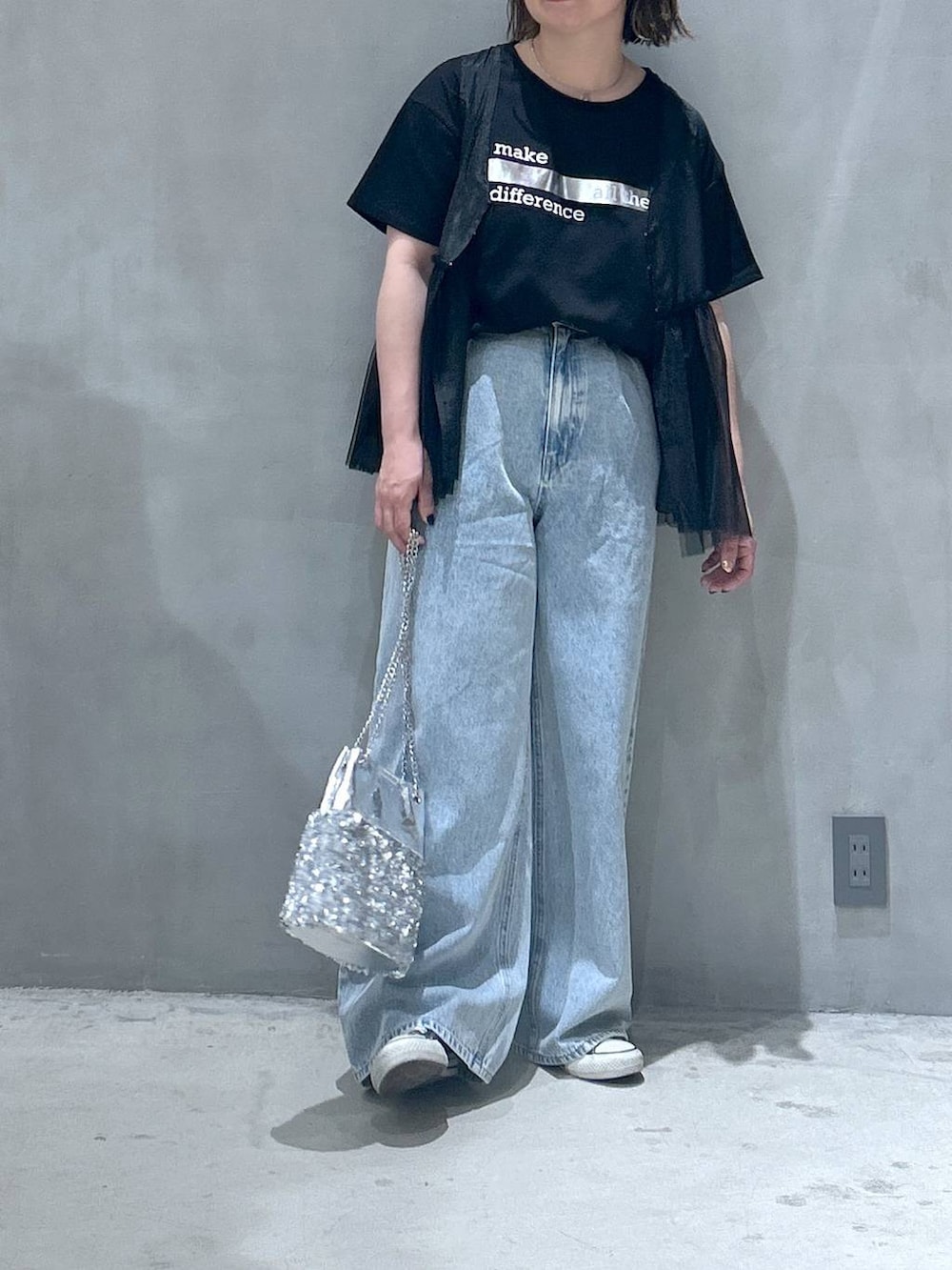 ブルー系のデニムパンツ、その他のショルダーバッグ、ブラック系のベストを着用したレディースの春コーディネートの4枚目の写真