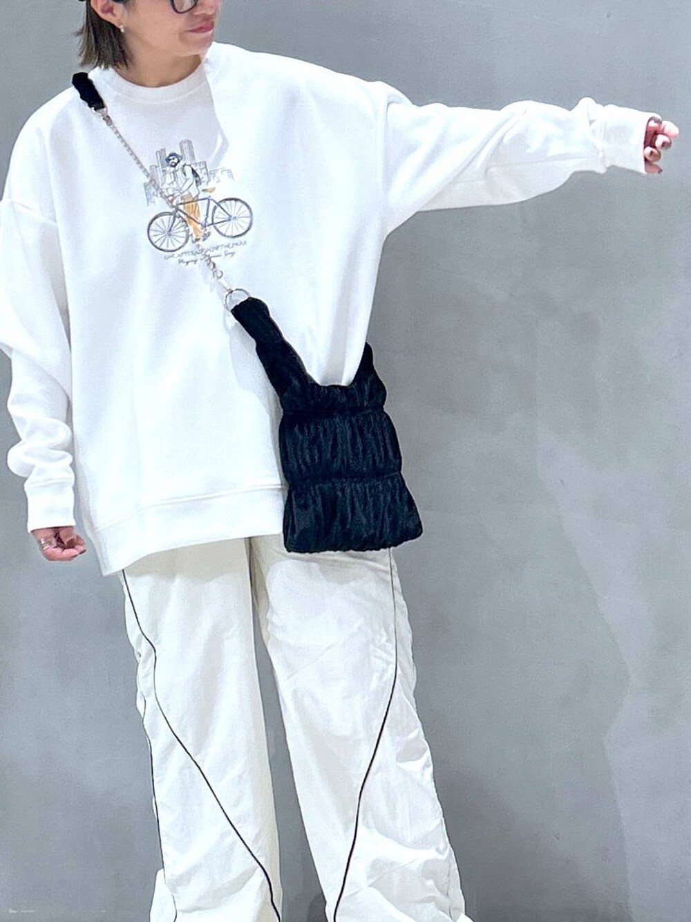 ホワイト系のスニーカー、ブラック系のショルダーバッグ、ベージュ系のその他パンツを着用したレディースの秋コーディネートの3枚目の写真