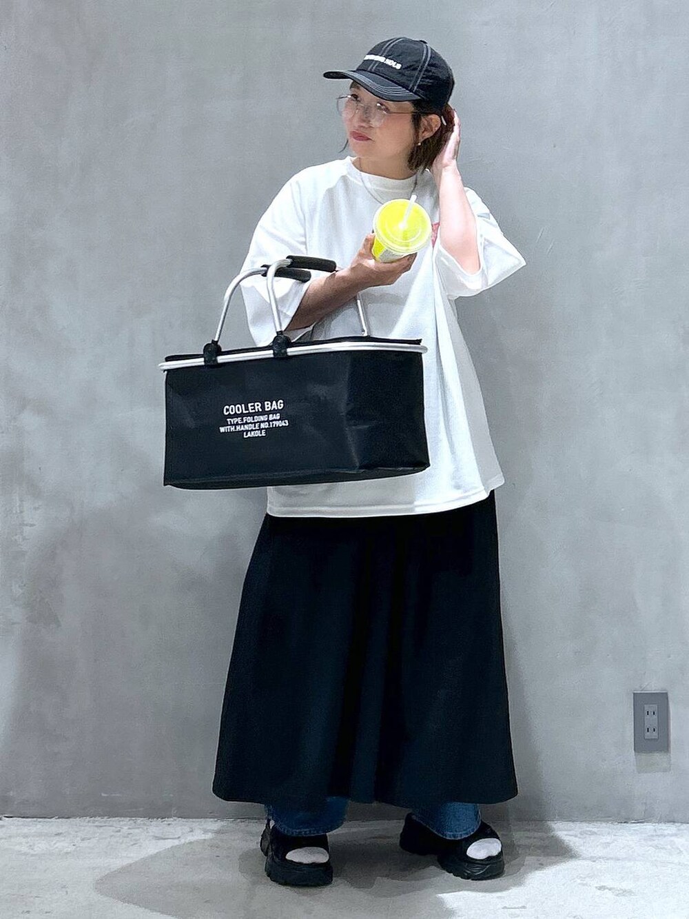 ブルー系のデニムパンツ、ブラック系のスニーカー、ブラック系のワンピースを着用したレディースの春コーディネートの7枚目の写真