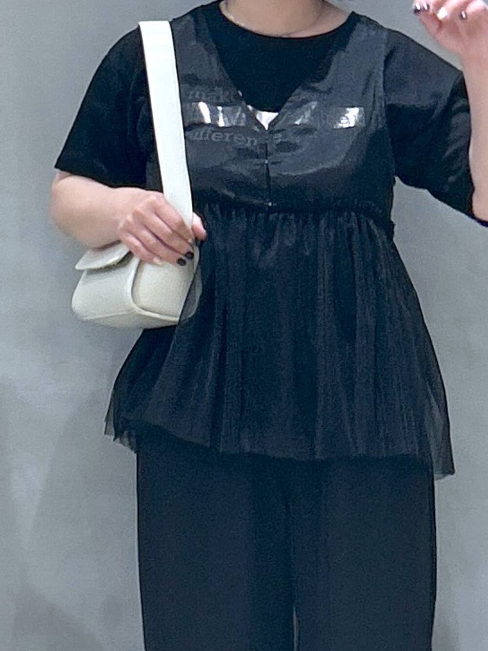 ブラック系のその他パンツ、ホワイト系のショルダーバッグ、ブラック系のベストを着用したレディースの春コーディネートの3枚目の写真