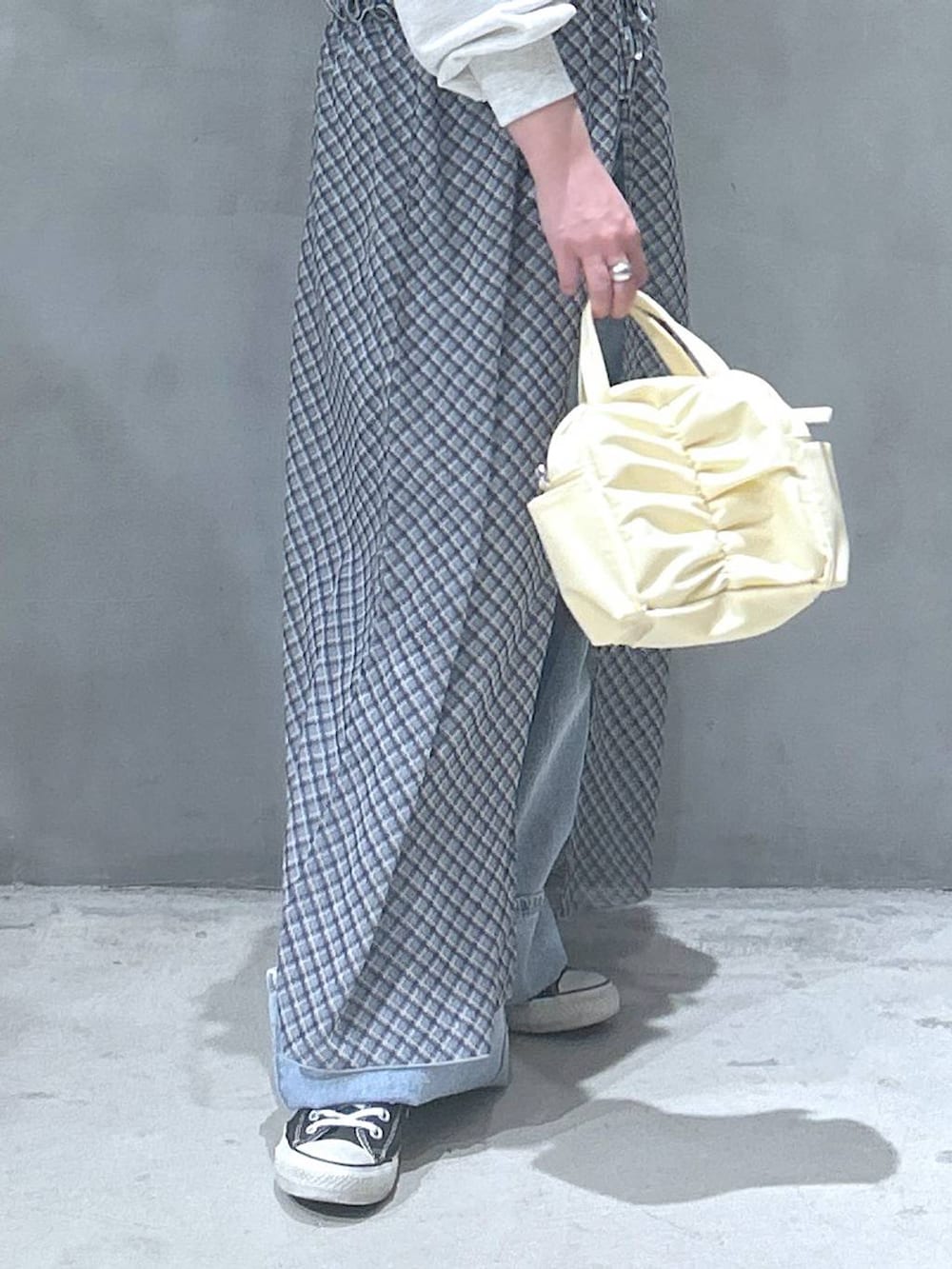 ブルー系のデニムパンツ、ベージュ系のスウェット、ブルー系のワンピースを着用したレディースの春コーディネートの4枚目の写真