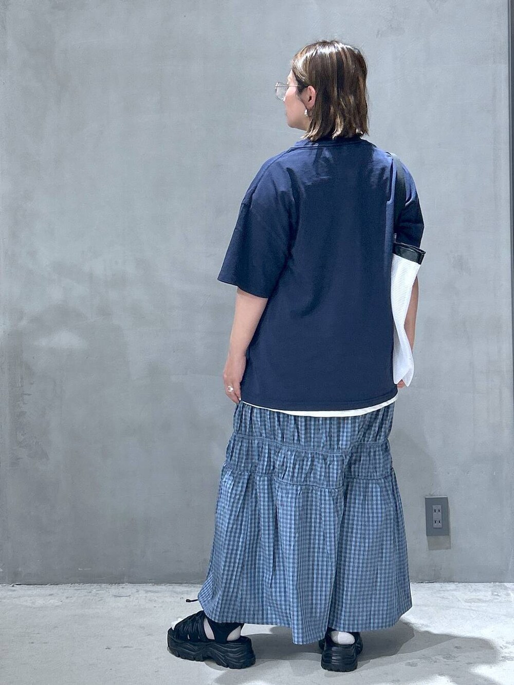 ブラック系のスニーカー、ホワイト系のTシャツ/カットソー、ブラック系のスマホグッズを着用したレディースの春コーディネートの2枚目の写真