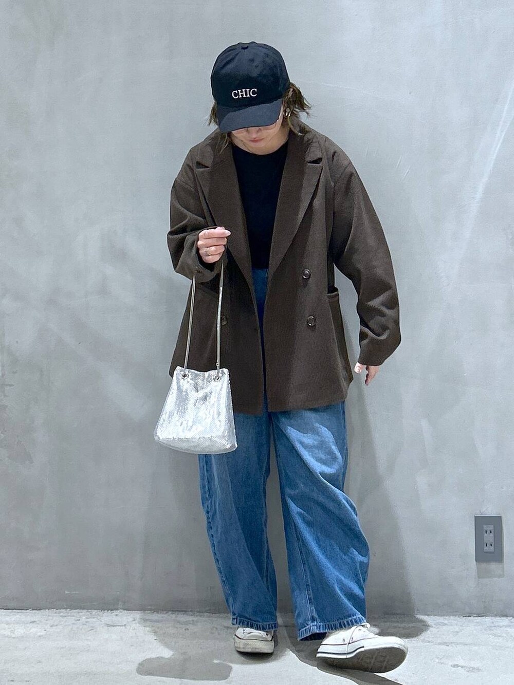 ブルー系のデニムパンツ、ブラウン系のテーラードジャケット、その他のショルダーバッグを着用したレディースの秋コーディネートの5枚目の写真