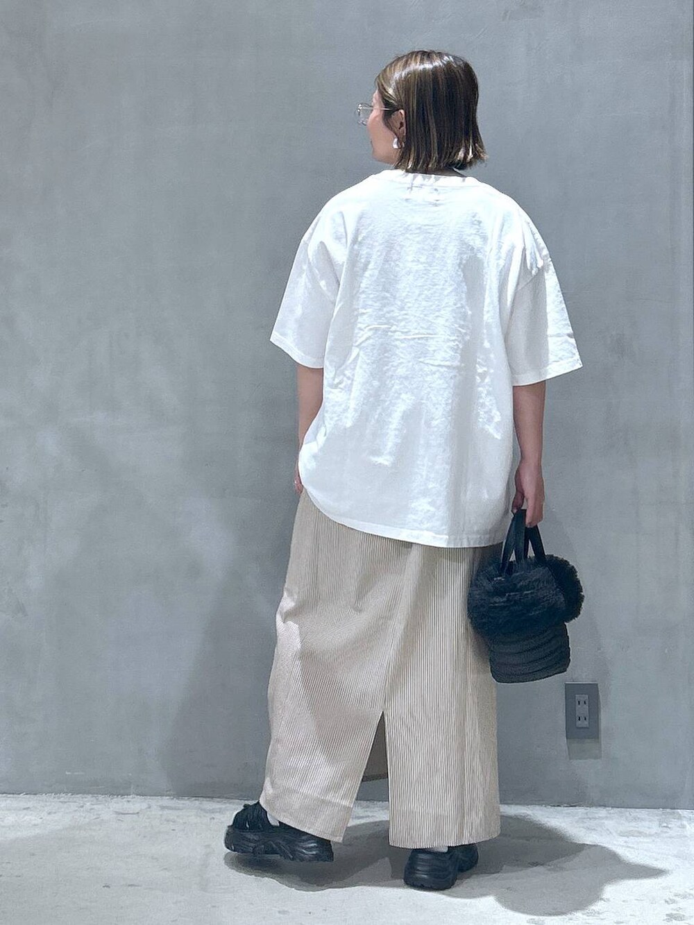 ブラック系のショルダーバッグ、ホワイト系のTシャツ/カットソー、ベージュ系のワンピースを着用したレディースの夏コーディネートの2枚目の写真