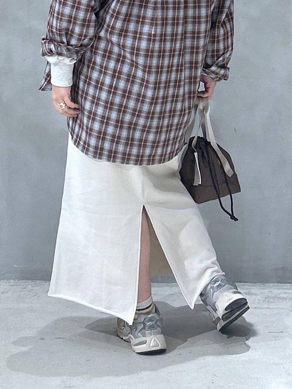 ベージュ系のスウェット、ブラウン系のシャツ/ブラウス、ホワイト系のスカートを着用したレディースの冬コーディネートの3枚目の写真