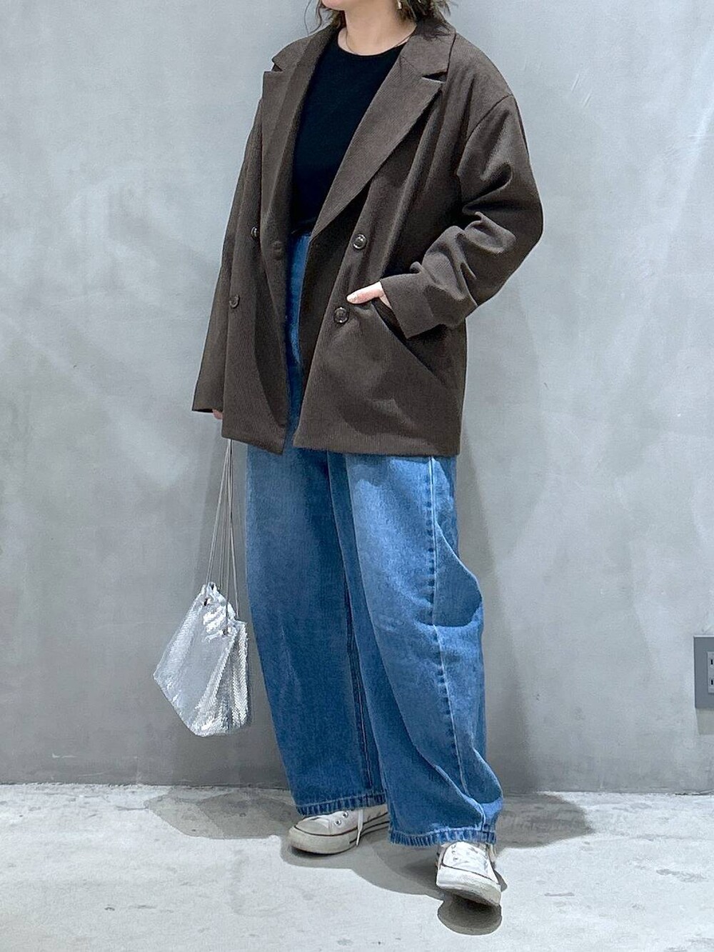 ブルー系のデニムパンツ、ブラウン系のテーラードジャケット、その他のショルダーバッグを着用したレディースの秋コーディネートの4枚目の写真