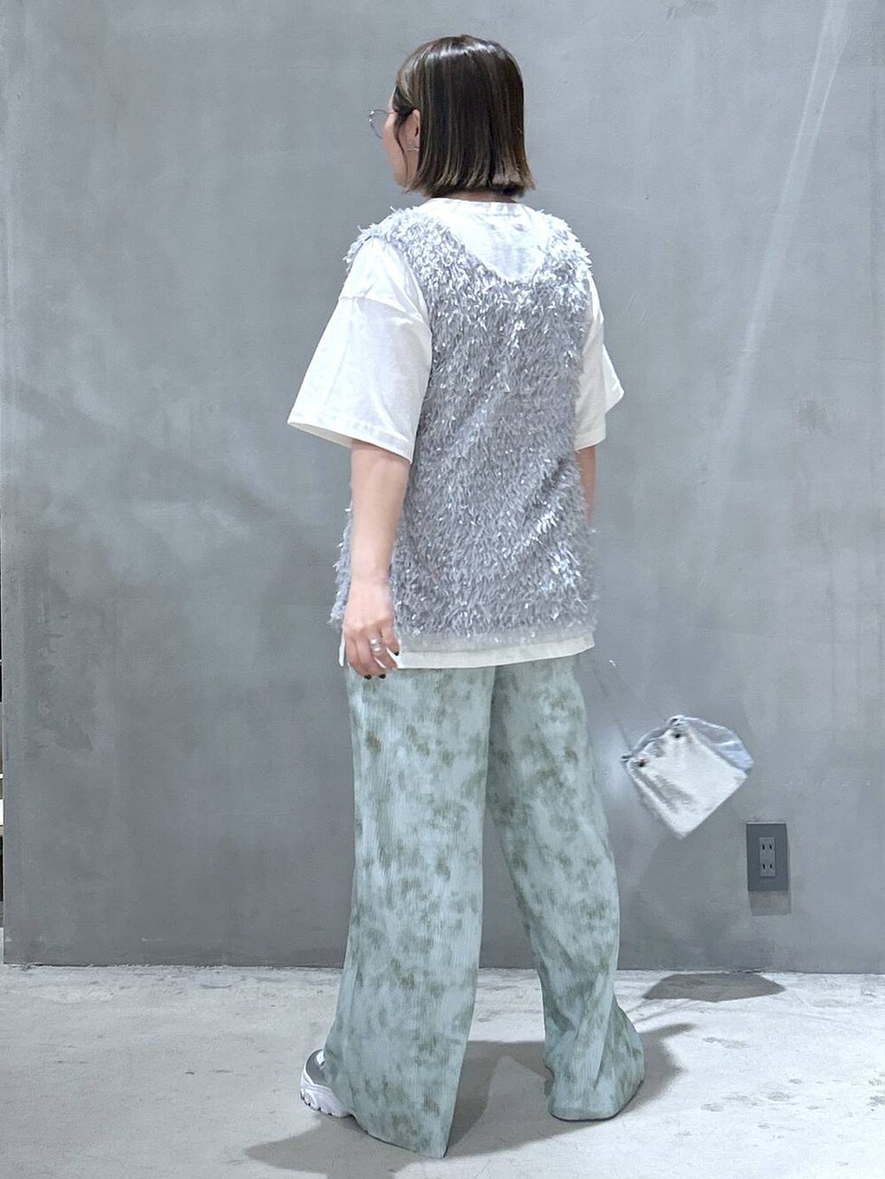 その他のショルダーバッグ、シルバー系のスニーカー、グレー系のベストを着用したレディースの春コーディネートの6枚目の写真