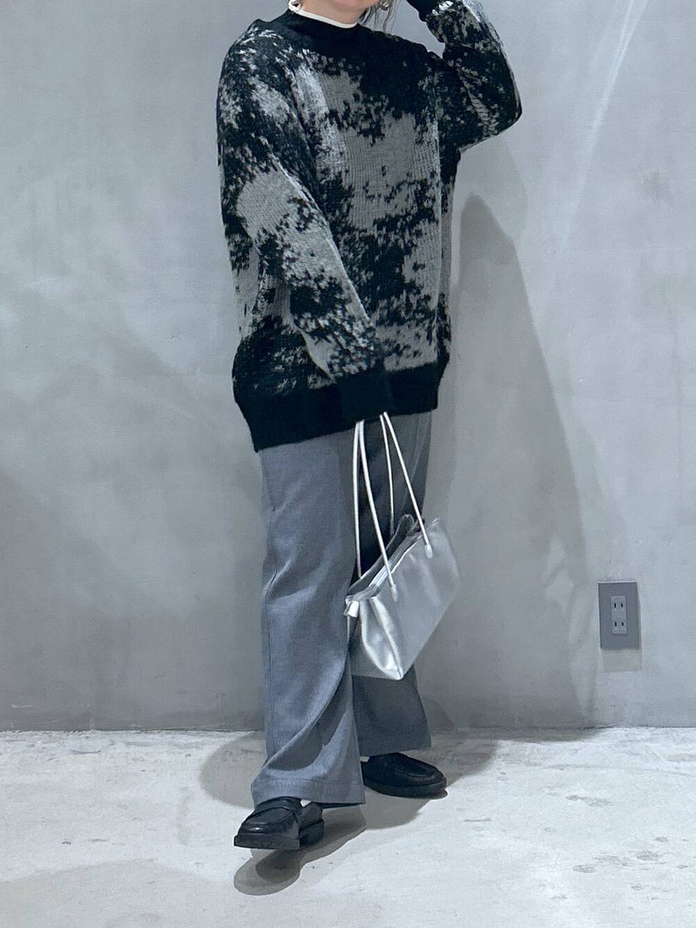 ブラック系のニット/セーター、ブラック系のローファー、シルバー系のトートバッグを着用したレディースの秋コーディネートの6枚目の写真