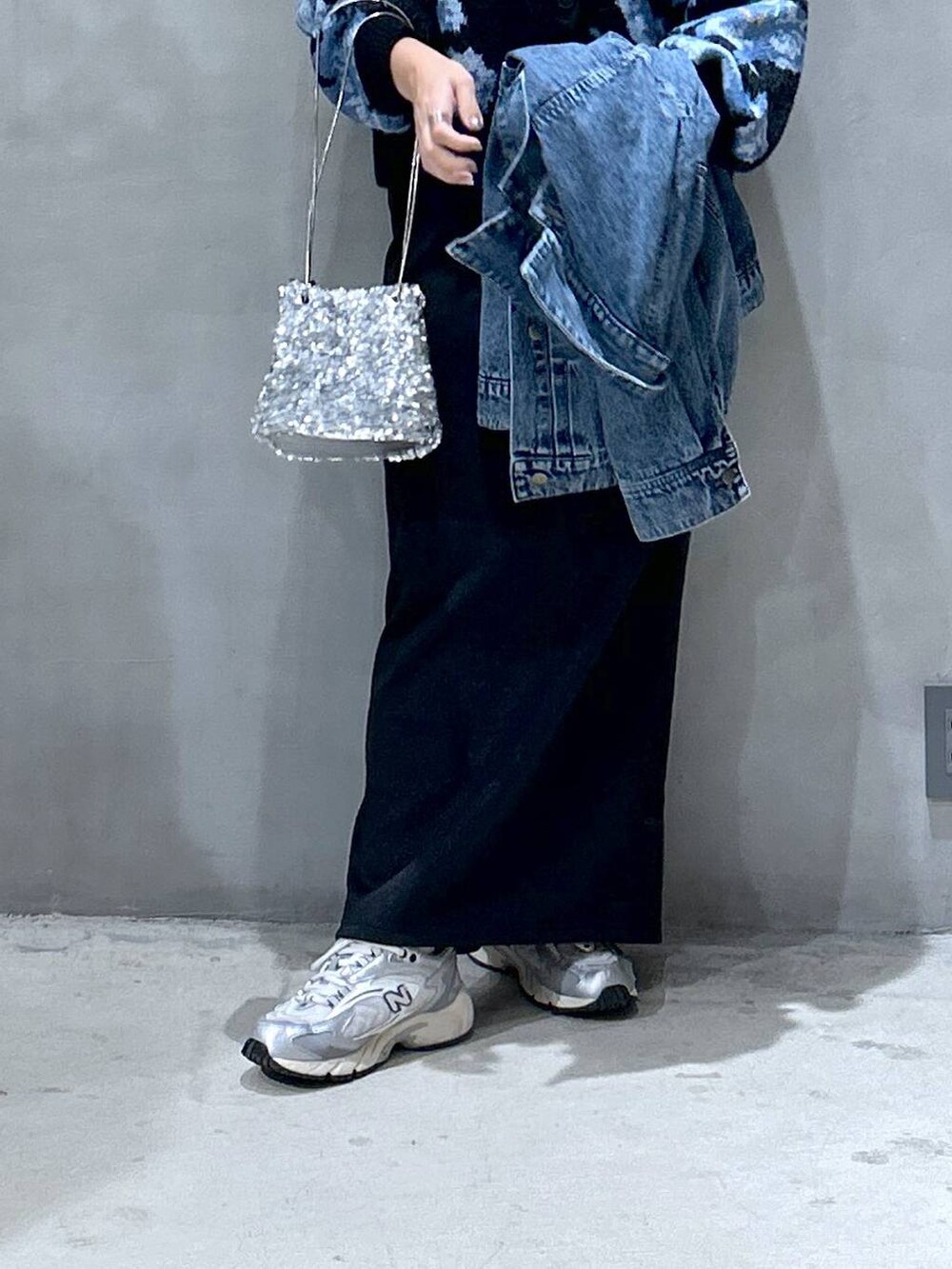 グレー系のスニーカー、ブラック系のカーディガン/ボレロ、ブルー系のデニムジャケットを着用したレディースの秋コーディネートの4枚目の写真