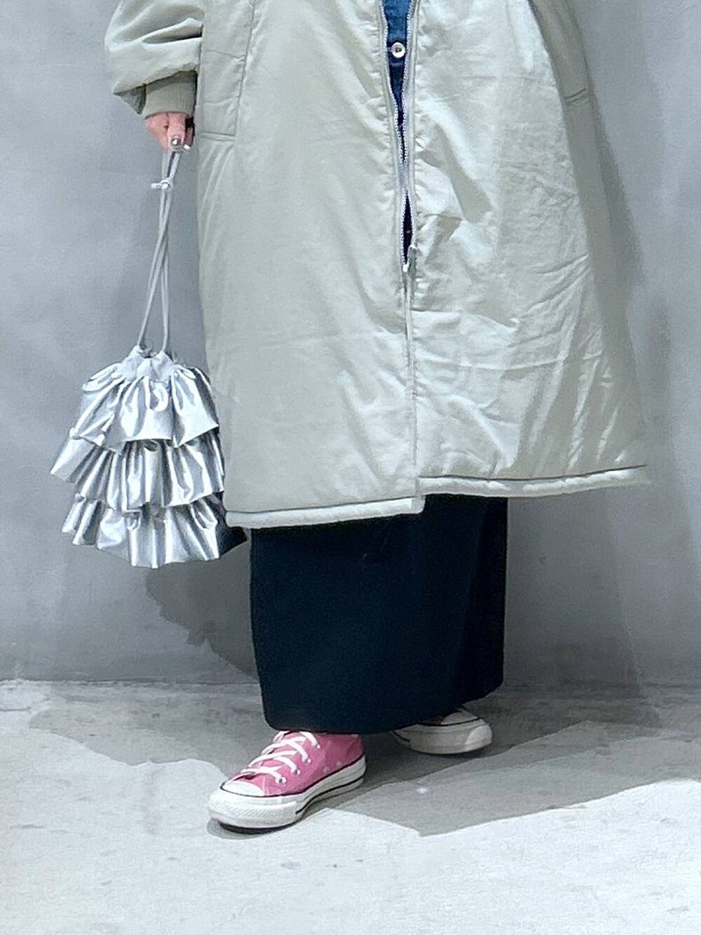 グリーン系のミリタリージャケット、ブラック系のスカート、シルバー系のショルダーバッグを着用したレディースの冬コーディネートの5枚目の写真