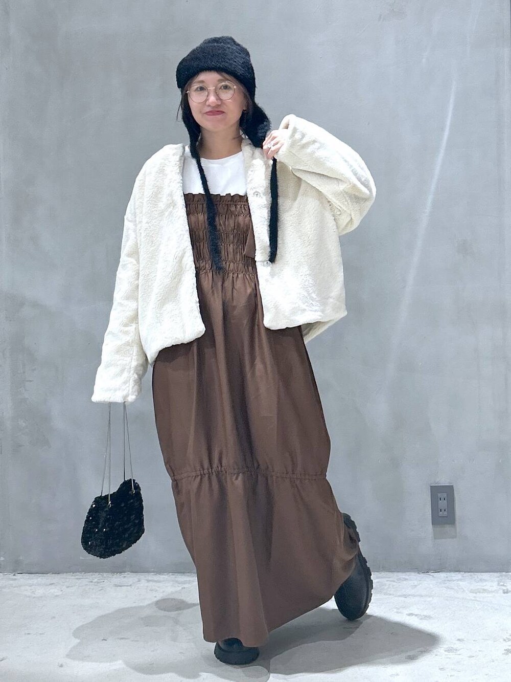 ベージュ系のブルゾン、ブラック系のブーツ、ブラウン系のワンピースを着用したレディースの秋コーディネートの6枚目の写真