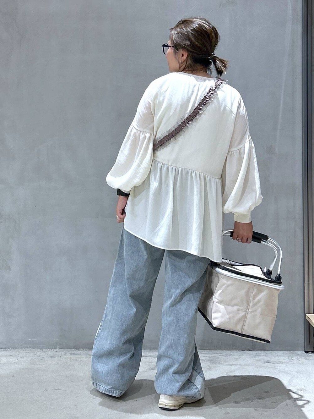 ブルー系のデニムパンツ、ホワイト系のチュニック、その他のサングラスを着用したレディースの秋コーディネートの2枚目の写真