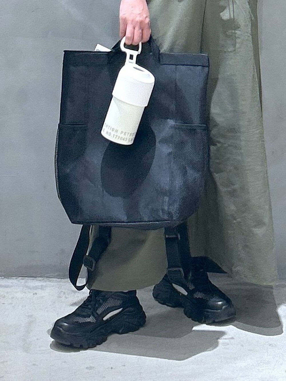 ブラック系のバックパック/リュック、ブラック系のスニーカー、グリーン系のTシャツ/カットソーを着用したレディースの春コーディネートの4枚目の写真