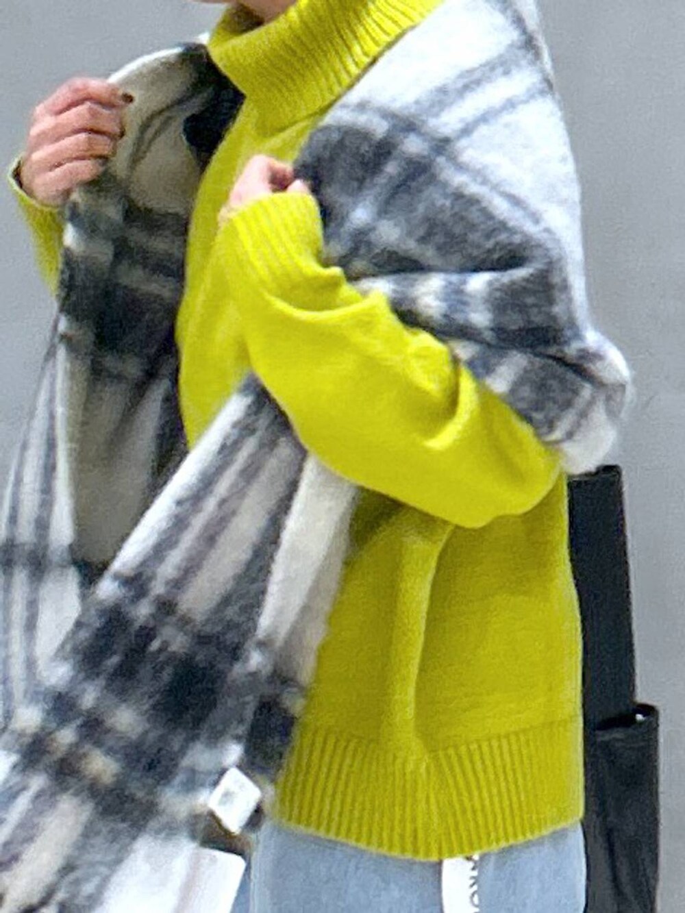 ブルー系のデニムパンツ、グリーン系のニット/セーター、ブラック系のトートバッグを着用したレディースの冬コーディネートの3枚目の写真