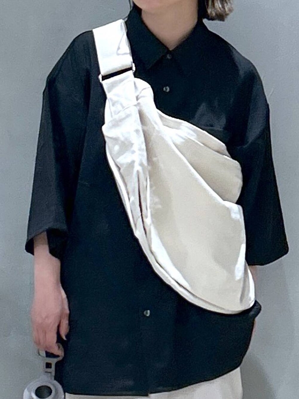 ベージュ系のショルダーバッグ、ブラック系のスニーカー、ベージュ系のスカートを着用したレディースの春コーディネートの4枚目の写真