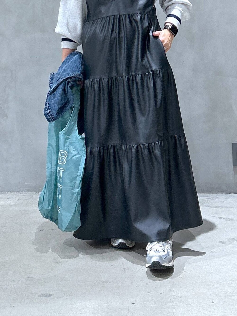 グレー系のスニーカー、ブラック系のワンピース、ブルー系のデニムジャケットを着用したレディースの秋コーディネートの5枚目の写真