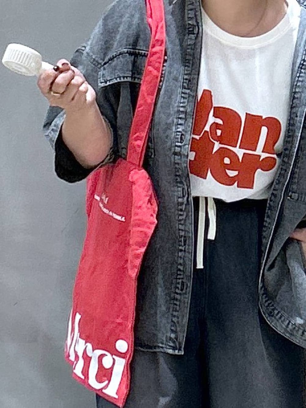 ブラック系のシャツ/ブラウス、レッド系のトートバッグ、ブラック系のデニムパンツを着用したレディースの夏コーディネートの4枚目の写真