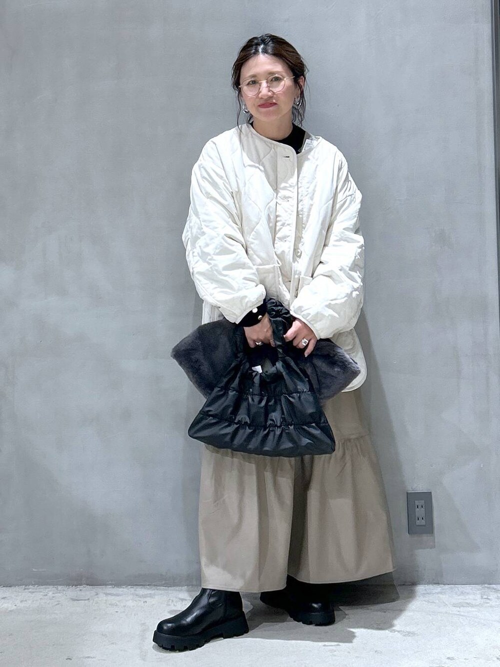 ブラック系のニット/セーター、ベージュ系のブルゾン、ブラック系のブーツを着用したレディースの秋コーディネートの5枚目の写真