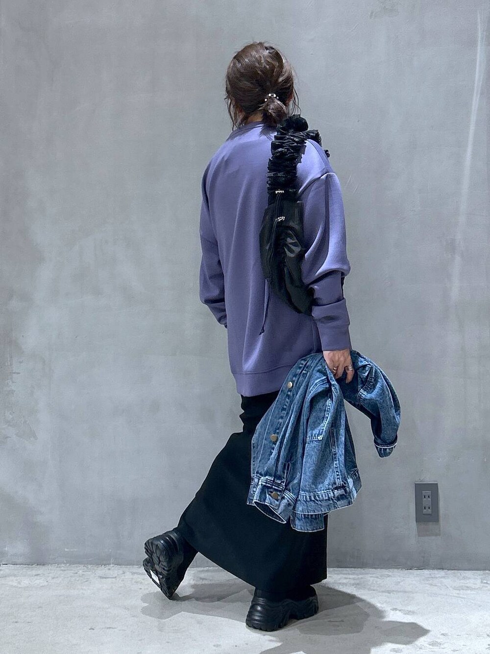 ブラック系のショルダーバッグ、パープル系のスウェット、ブラック系のブーツを着用したレディースの秋コーディネートの2枚目の写真