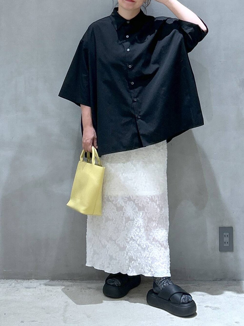 ブラック系のサンダル、ホワイト系のスカート、ブラック系のシャツ/ブラウスを着用したレディースの夏コーディネートの4枚目の写真