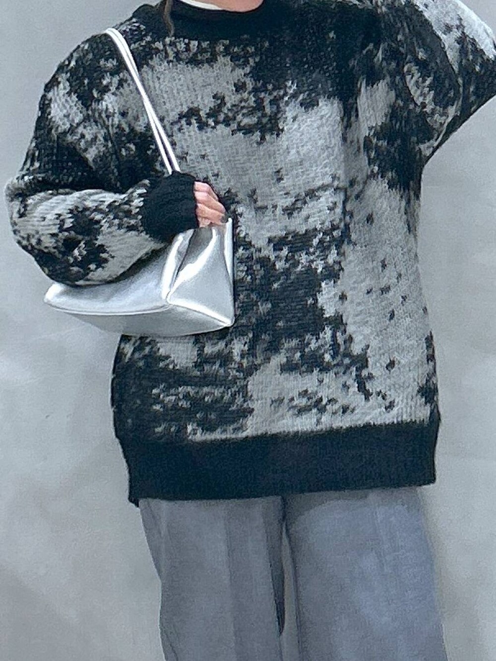 ブラック系のニット/セーター、ブラック系のローファー、シルバー系のトートバッグを着用したレディースの秋コーディネートの3枚目の写真