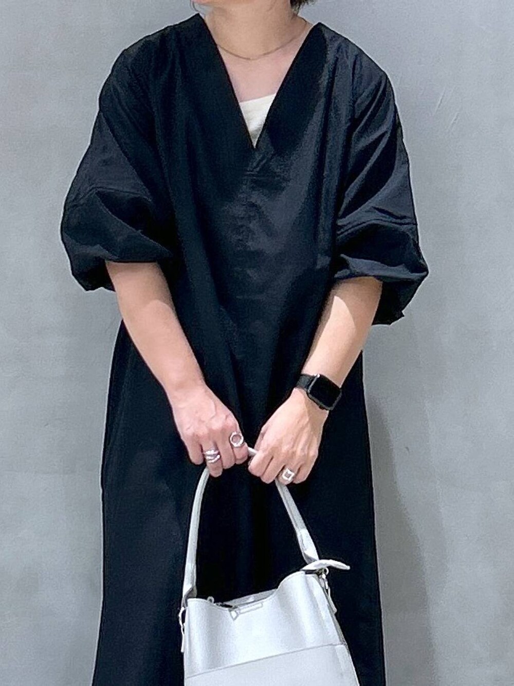 グレー系のショルダーバッグ、ブラック系のワンピース、グリーン系のキャップを着用したレディースの夏コーディネートの3枚目の写真