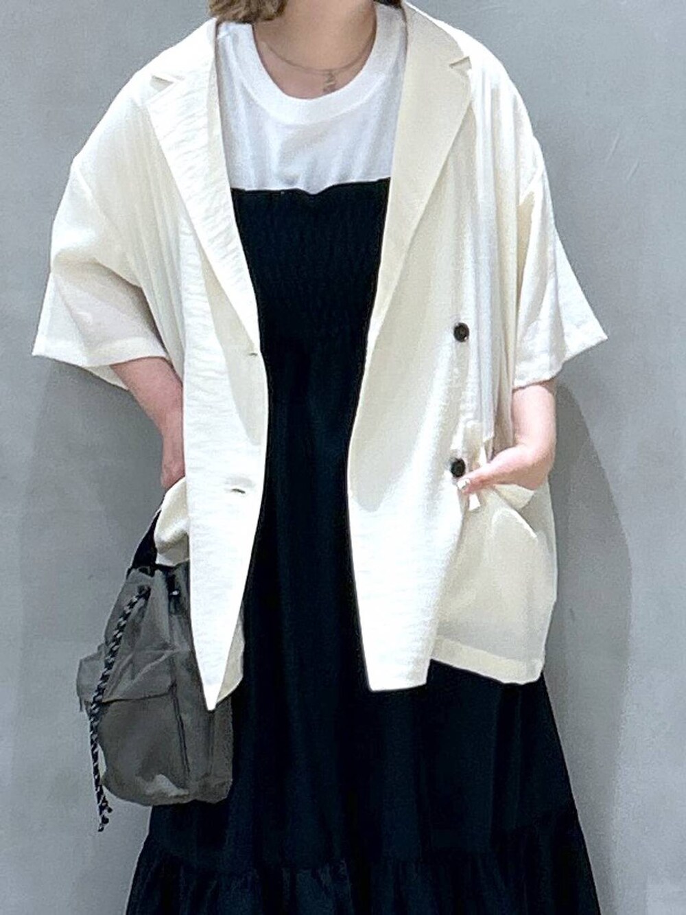 ブラック系のスニーカー、グリーン系のショルダーバッグ、ホワイト系のTシャツ/カットソーを着用したレディースの春コーディネートの3枚目の写真