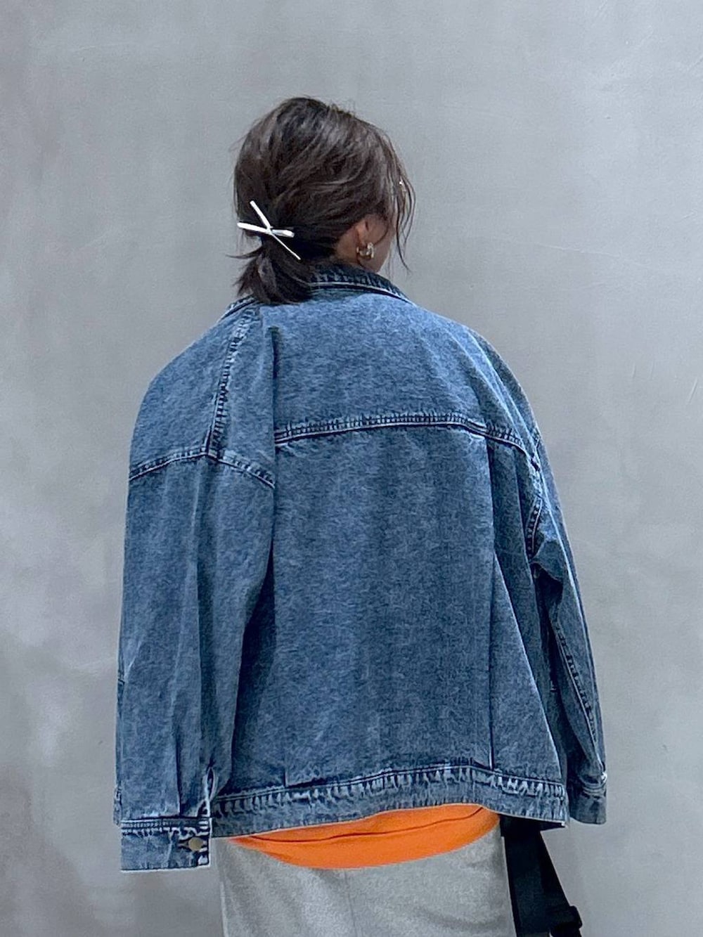 グレー系のスニーカー、ブラック系のショルダーバッグ、ブルー系のデニムジャケットを着用したレディースの秋コーディネートの6枚目の写真