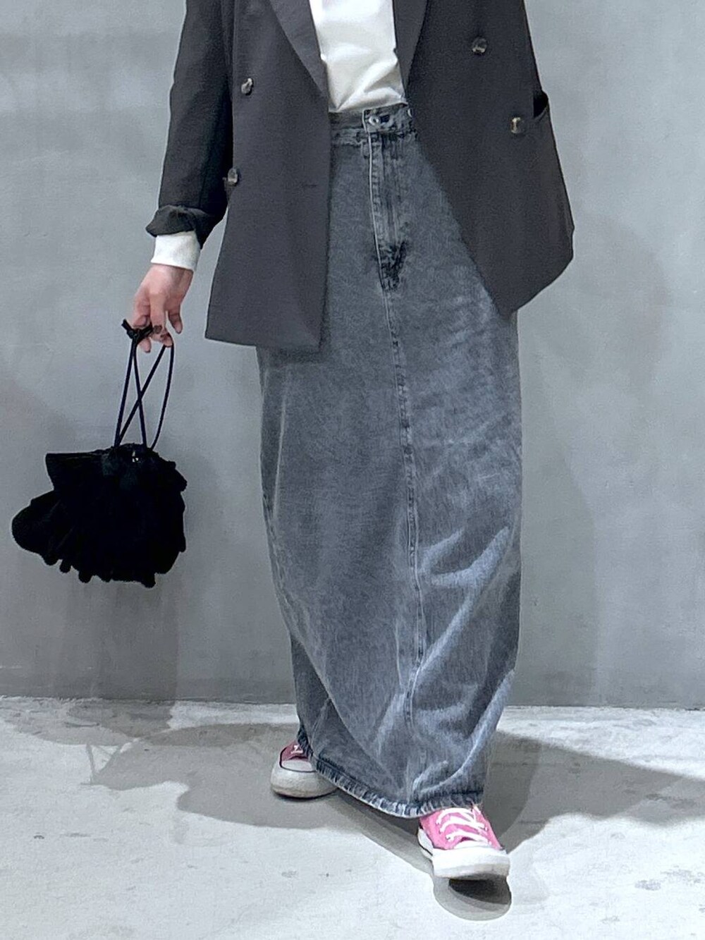 ブラック系のショルダーバッグ、ブラック系のジャンパースカート、グレー系のテーラードジャケットを着用したレディースの冬コーディネートの3枚目の写真