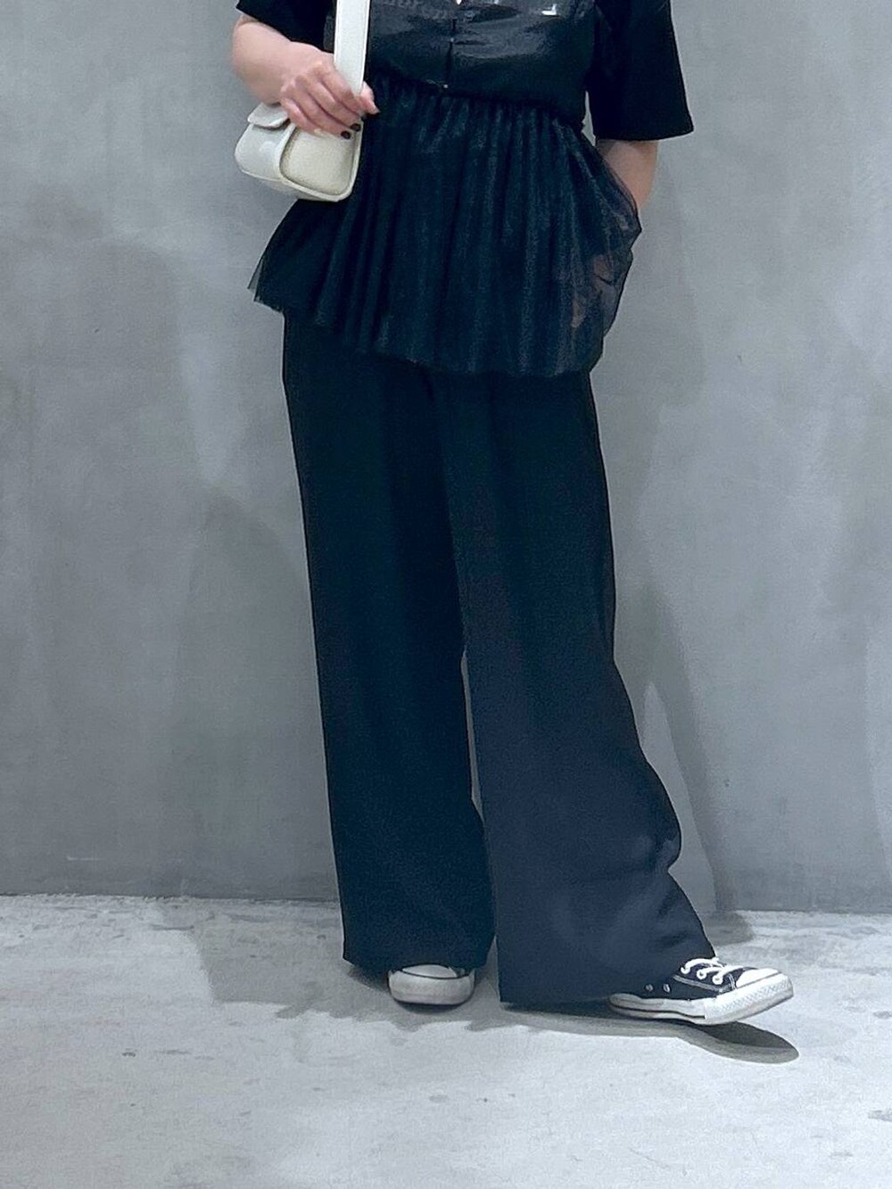 ブラック系のその他パンツ、ホワイト系のショルダーバッグ、ブラック系のベストを着用したレディースの春コーディネートの6枚目の写真