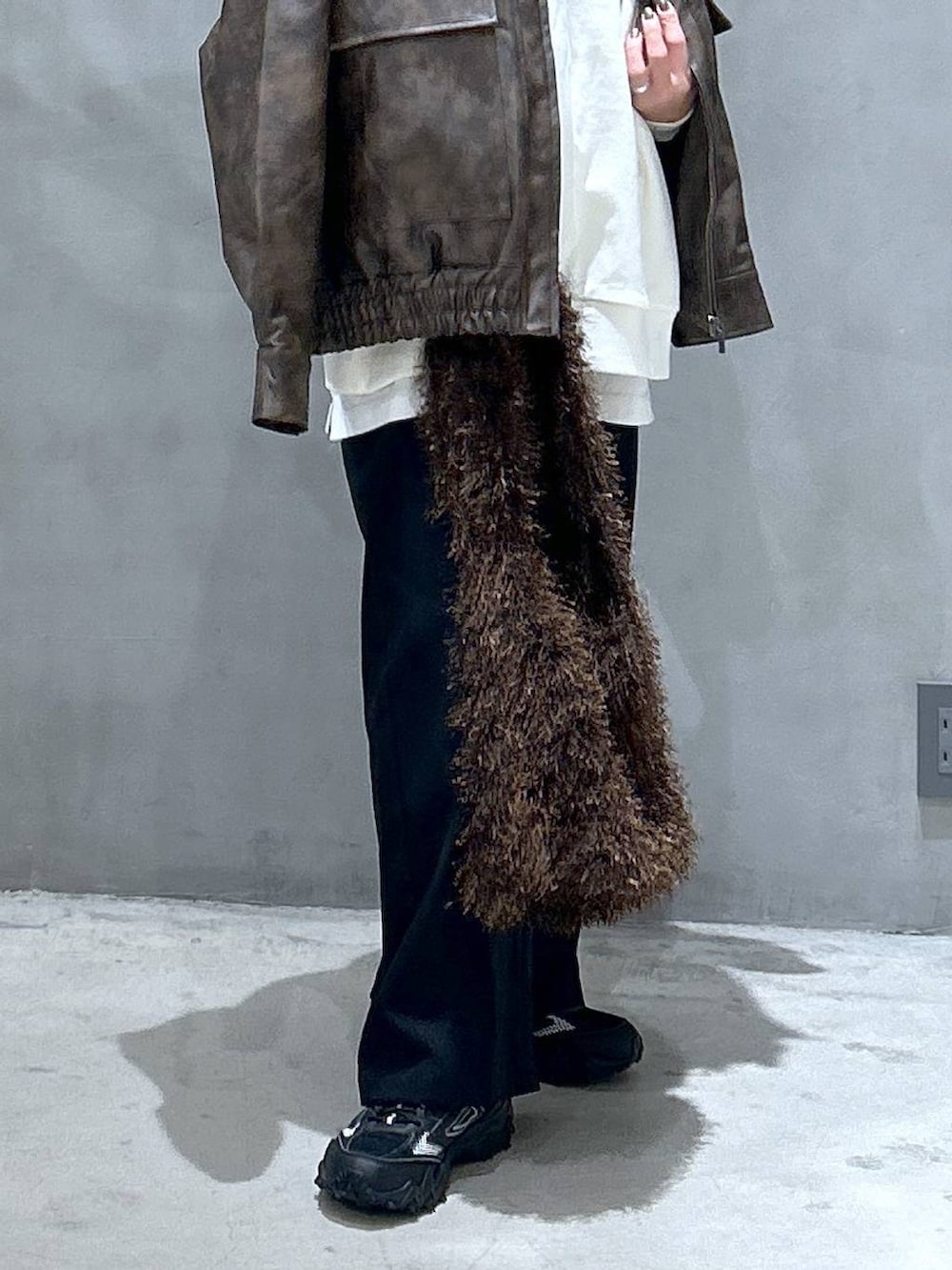 グレー系のスニーカー、ブラウン系のブルゾン、ブラウン系のショルダーバッグを着用したレディースの冬コーディネートの4枚目の写真