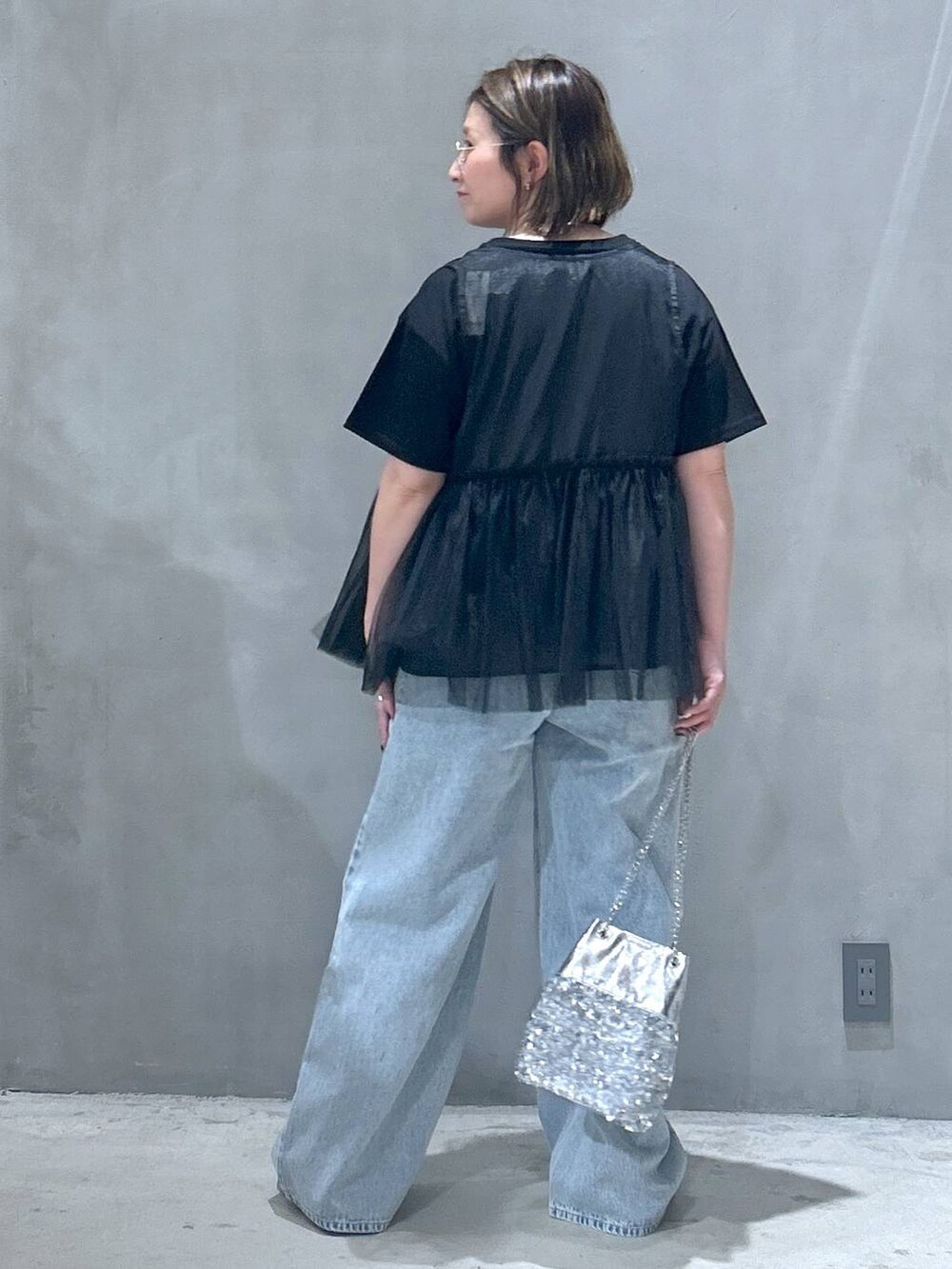 ブルー系のデニムパンツ、その他のショルダーバッグ、ブラック系のベストを着用したレディースの春コーディネートの2枚目の写真