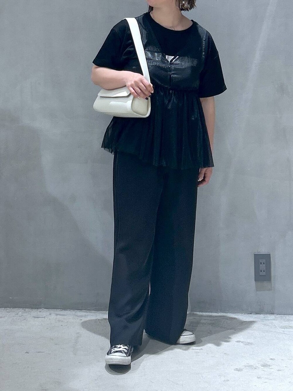 ブラック系のその他パンツ、ホワイト系のショルダーバッグ、ブラック系のベストを着用したレディースの春コーディネートの4枚目の写真