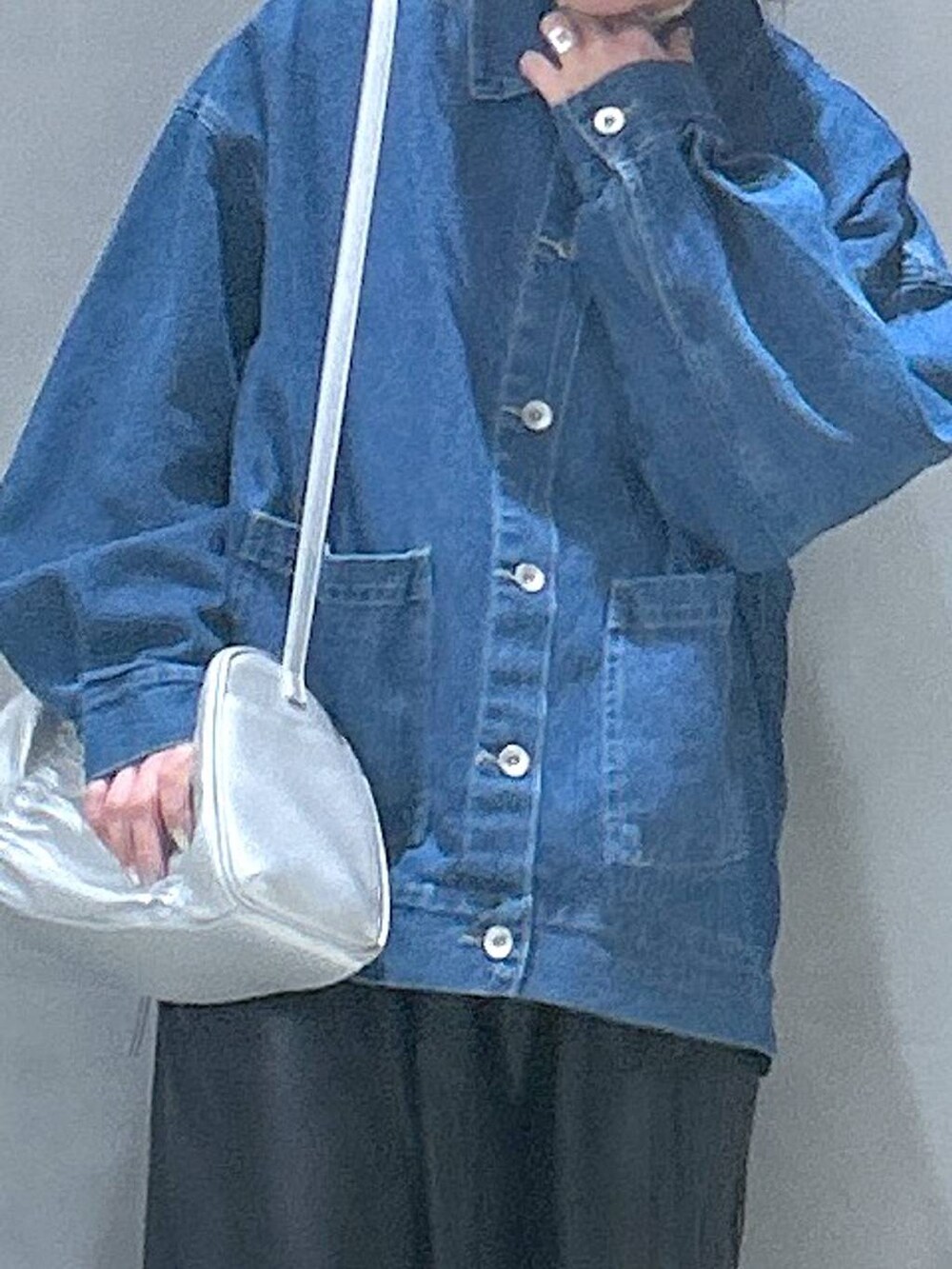 ブラック系のワンピース、シルバー系のショルダーバッグ、ブルー系のデニムジャケットを着用したレディースの冬コーディネートの3枚目の写真