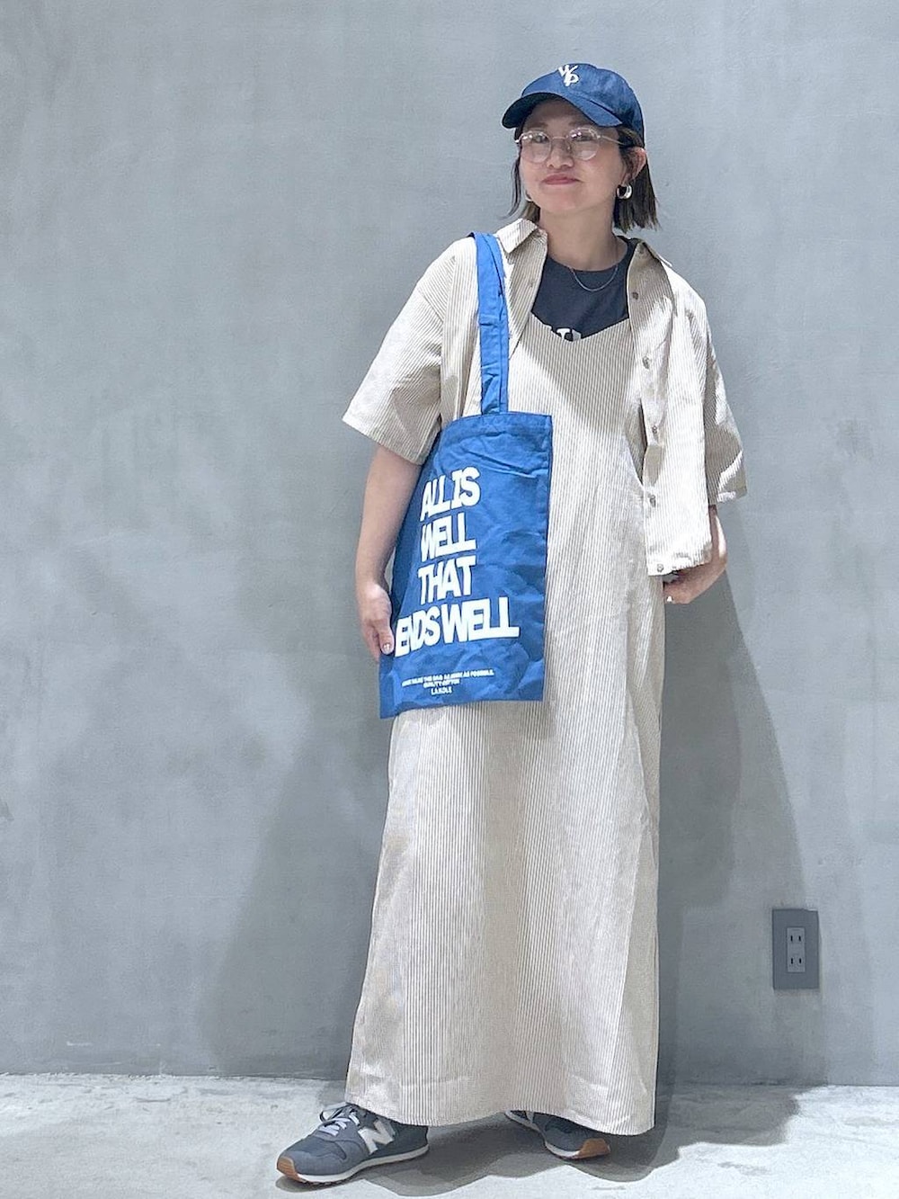 グレー系のスニーカー、ブルー系のトートバッグ、グレー系のTシャツ/カットソーを着用したレディースの春コーディネートの5枚目の写真