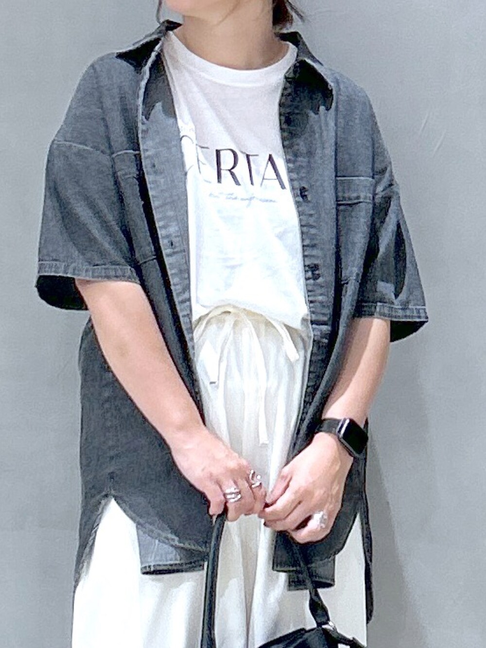 ブラック系のハンドバッグ、ホワイト系のその他パンツ、ブラック系のシャツ/ブラウスを着用したレディースの夏コーディネートの2枚目の写真