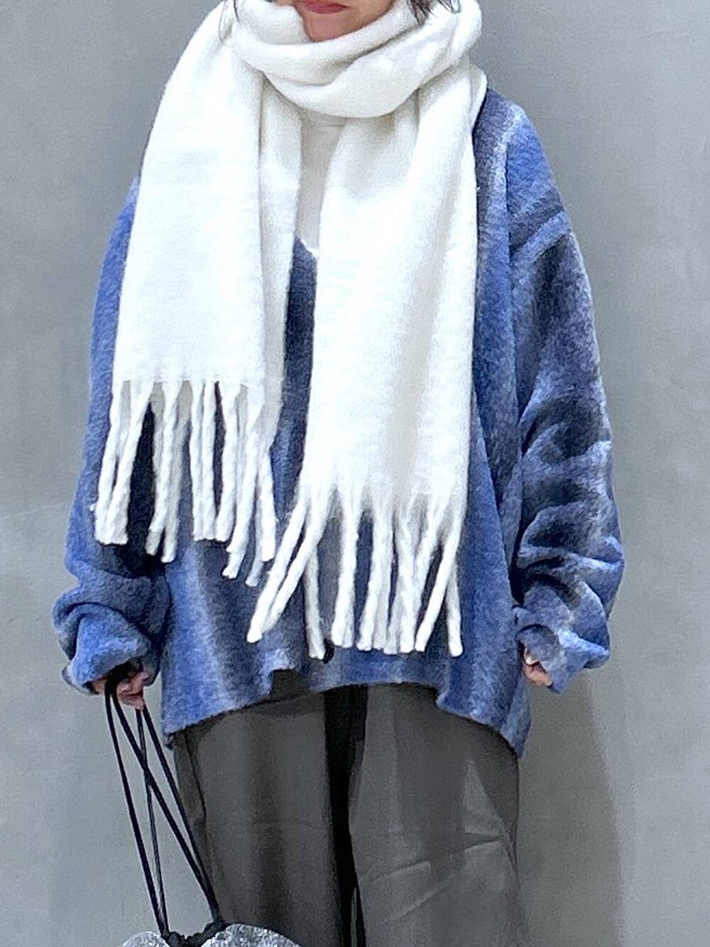 ブルー系のカーディガン/ボレロ、ベージュ系のその他パンツ、シルバー系のショルダーバッグを着用したレディースの冬コーディネートの2枚目の写真