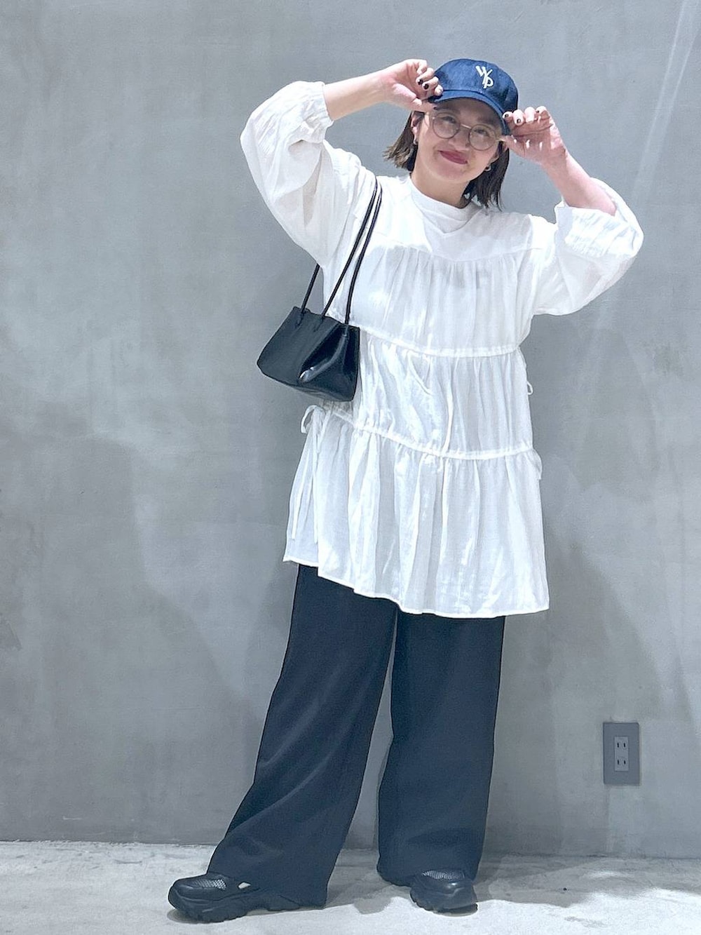 ブラック系のトートバッグ、ブラック系のスニーカー、ブラック系のその他パンツを着用したレディースの春コーディネートの6枚目の写真