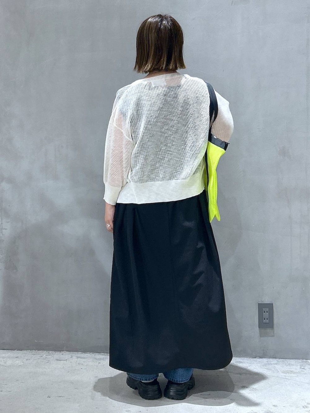 ブルー系のデニムパンツ、ブラック系のスニーカー、ホワイト系のカーディガン/ボレロを着用したレディースの春コーディネートの2枚目の写真