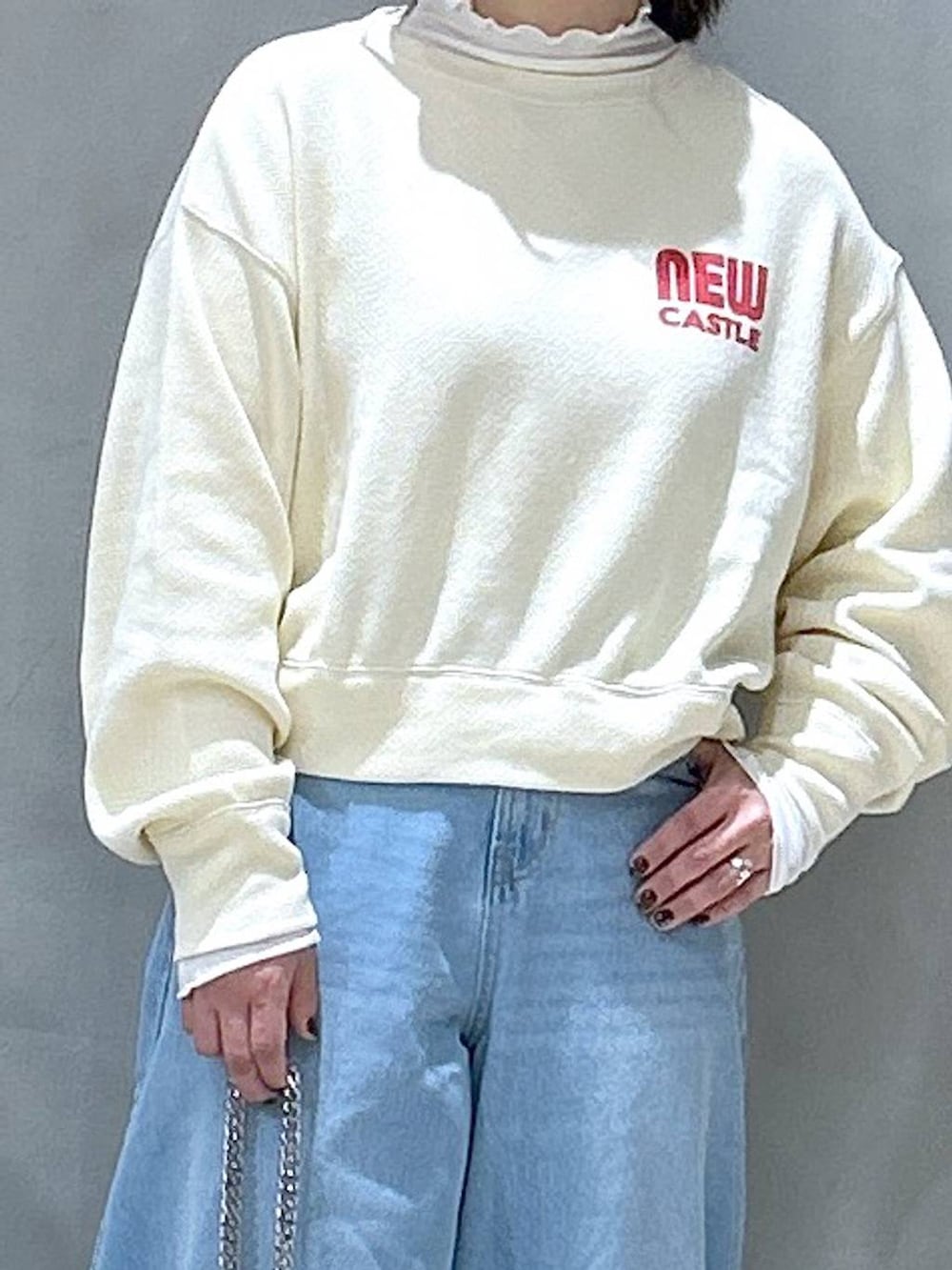 ブルー系のデニムパンツ、ベージュ系のTシャツ/カットソー、ブラック系のショルダーバッグを着用したレディースの冬コーディネートの3枚目の写真