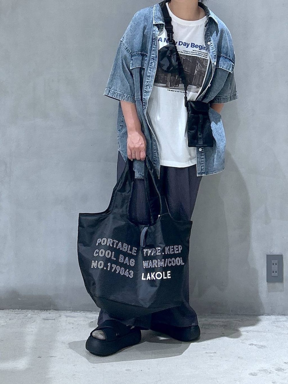 ブラック系のショルダーバッグ、ブラック系のサンダル、ブルー系のシャツ/ブラウスを着用したレディースの夏コーディネートの4枚目の写真