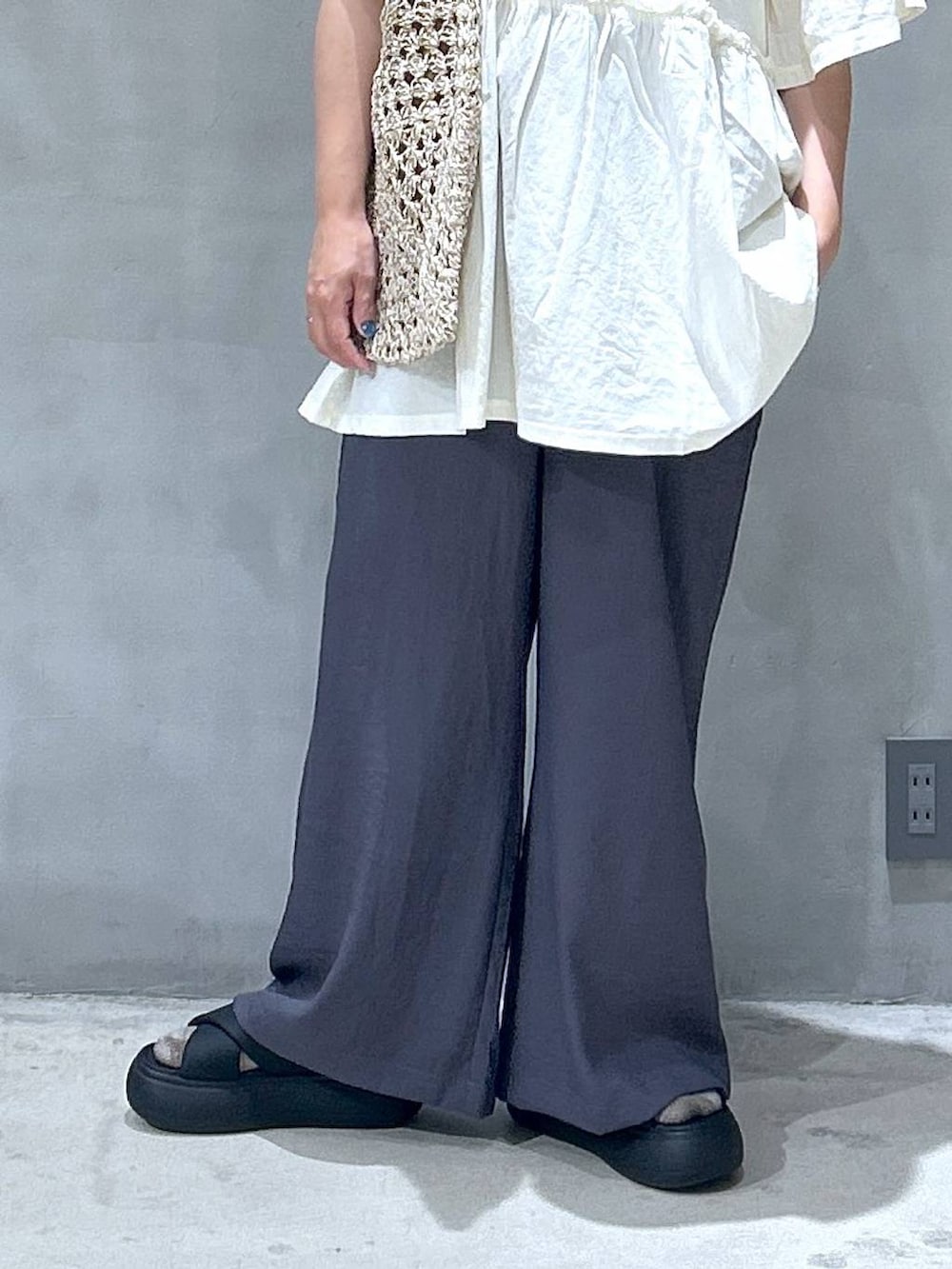 ベージュ系のトートバッグ、ブラック系のサンダル、グレー系のその他パンツを着用したレディースの夏コーディネートの4枚目の写真